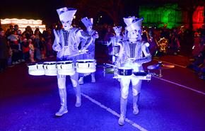 Illuminated drummers in festive costume taking part in the Swansea Christmas Parade